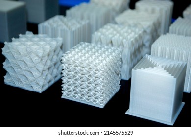 White models prototypes printed on 3D printer from plastic close-up. New progressive additive modern 3D printing technology. Three-dimensional object created by high-precision 3D printing technologies