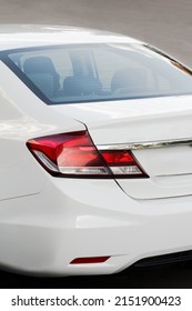 White Modern Car Close-up Details. Back Side View With Headlight And Bumper Details. Beautiful Curved Shapes With Modern Stylish Design