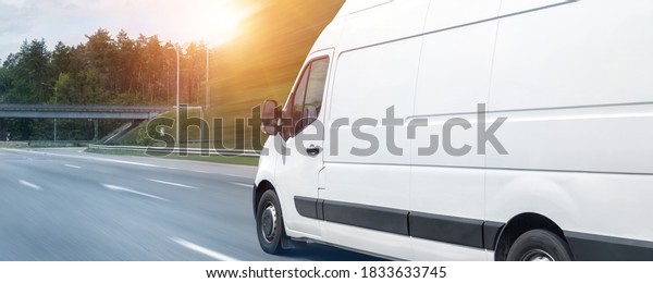 White modern delivery small shipment cargo courier\
van moving fast on motorway road to city urban suburb. Busines\
distribution and logistics express service. Mini bus driving on\
highway day. banner