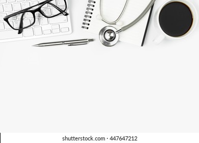 White Modern Doctor Desk Table With Stethoscope, Coffee Cup And Office Supplies. Top View With Copy Space, Flat Lay.