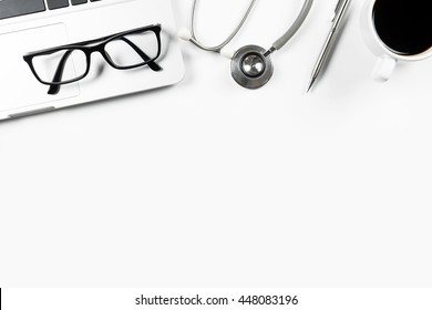 White Modern Doctor Desk Table With Stethoscope, Laptop, Coffee Cup And Supplies. Top View With Copy Space, Flat Lay.