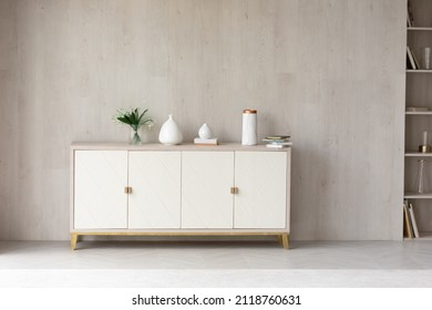 White modern dresser minimalistic furniture in empty room on grey wall background, small cupboard with decor, vases and lily of the valley flowers bouquet, cozy apartment house interior concept - Powered by Shutterstock