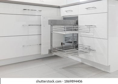 White Modern Kitchen Cabinets And Gray Quartz Countertop. Shows Stainless Steel Cabinet Pull-out Hardware. Porcelain Floor Tiles