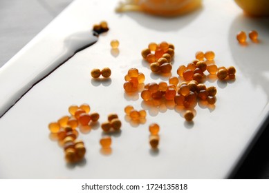 White Modern Plate With Salad, Gold Caviar And Gold Yolk Over A Black Slate Table