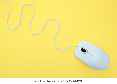 White modern wired computer mouse on yellow background