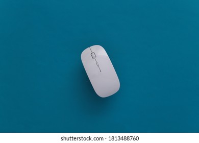 White Modern Wireless Pc Mouse On Blue Background. Top View