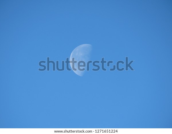 white moon in blue\
sky