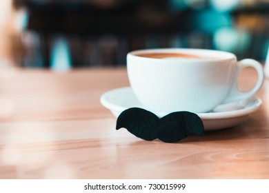 White Mug Of Coffee With Moustache On Wooden Table At Coffee Shop