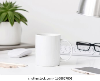 White mug mockup on workdesk with keyboard desk lamp, mouse and pencils