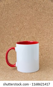 White Mug With A Red Handle On A Background Of A Textured Cork.