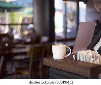 White Mug Stands On Coffee Shop Counter 