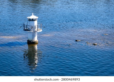White navigation marker reflected in the water in the Stockholm archipelago, Sweden.