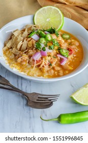 White Navy Bean Chicken Chili With Tortilla Strips Lime Cilantro And Shredded Cheese Garnish