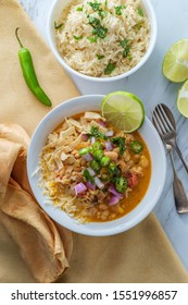 White Navy Bean Chicken Chili With Tortilla Strips Lime Cilantro And Shredded Cheese Garnish