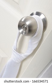 White Necktie Hanging On Knob