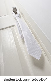 White Necktie Hanging On Knob