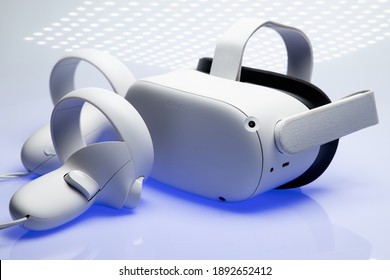 White new generation VR headset isolated on white background  with blue sparkling futuristic lights. Oculus Quest 2 virtual reality headset Amsterdam, the Netherlands 2021.01.01  