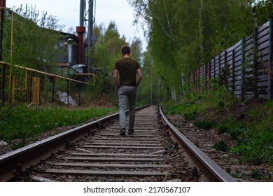 White Nights. Summer night walk in rain on train tracks of lonely person, view from back, selective or soft focus. Escapism concept