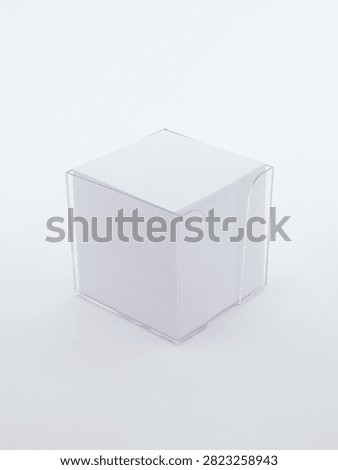 White note paper block cube in transparent plastic holder on white background