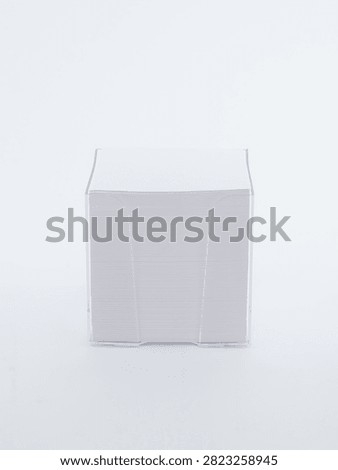 White note paper block cube in transparent plastic holder on white background