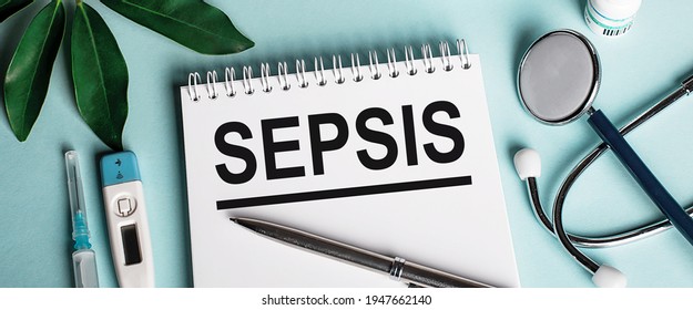 In a white notebook on a blue background, near a sheet of shefflers, a stethoscope, a syringe and an electronic thermometer, the word SEPSIS is written. Medical concept