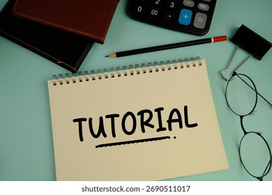 a white notebook with words TUTORIAL as an education concept
