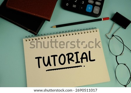 a white notebook with words TUTORIAL as an education concept