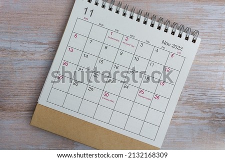 White November 2022 calendar on wooden background with daily holiday events. Flat lay. Directly above.