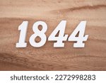 White number 1844 on a brown and light brown wooden background.