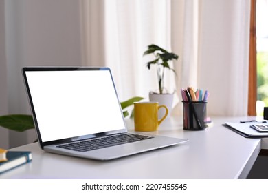 White office desk with laptop computer, coffee cup, potted plant and stationery. Comfortable workplace - Powered by Shutterstock