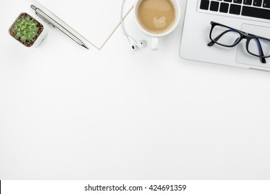 White office desk with laptop, cup of coffee and supplies. Top view with copy space. - Shutterstock ID 424691359
