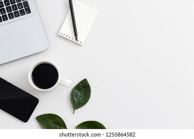 White office desk with laptop, office plant and notebook, mobile phone, green. Top view with copy space, flat lay - Shutterstock ID 1255864582