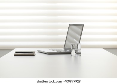 white office desk with note pad and laptop - Powered by Shutterstock