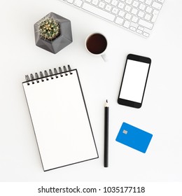 White Office Desk With Spiral Notebook, Credit Card, Cactus And Smartphone For Mock Up Or Product Montage. Internet Payment Concept. Flat Lay