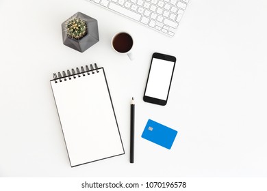 White Office Desk With Spiral Notebook, Credit Card, Cactus And Smartphone For Mock Up Or Product Montage. Internet Payment Concept. Flat Lay