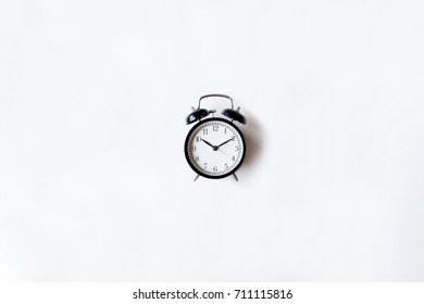 White Office Desk Table With Alarm Clock. Top View With Copy Space, Flat Lay.