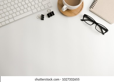Weißer Schreibtisch mit leerem Notebook, Computer, Zubehör und Kaffeetasse. Draufsicht mit Kopienraum.Flat lay.