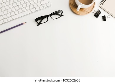 White Office Desk Table With Blank Notebook, Computer, Supplies And Coffee Cup. Top View With Copy Space. Flat Lay.