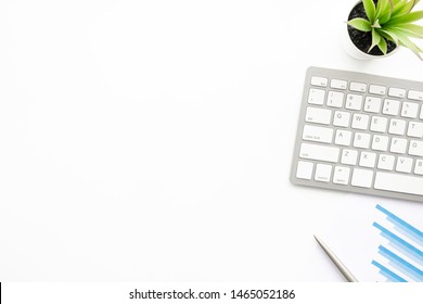 White office desk table with computer keyboard, business document charts and pen. Top view with copy space, flat lay.