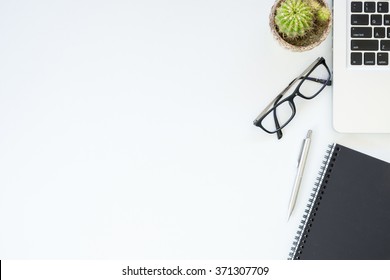 White Office Desk Table With Laptop, Notebook, And A Cup Of Coffee. Top View With Copy Space.