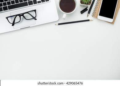 White office desk table with laptop, cup of coffee and supplies. Top view with copy space. - Shutterstock ID 429065476