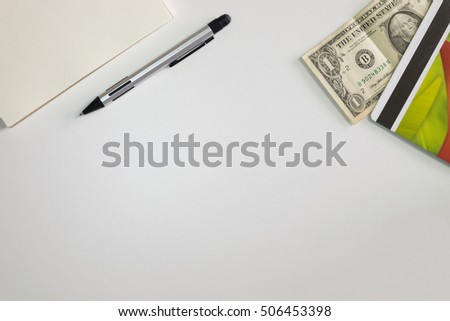 White office desk table with a saving books and coin and notebank, with copy space, for business or education concept