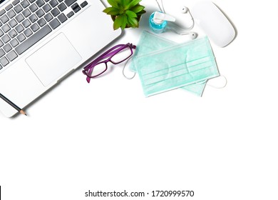 White Office Desk Table With Surgical Face Mask And Sanitizer Bottle Or Alcohol Gel With Laptop Isolated On White Background, Work From Home And Covid-19 Concept And New Normal