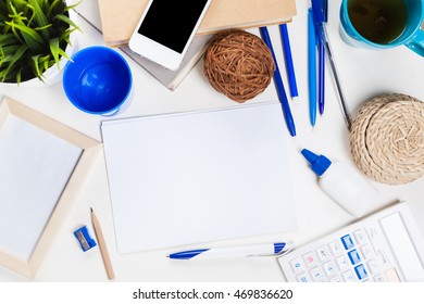 White office desk table with a lot of things on it. Top view