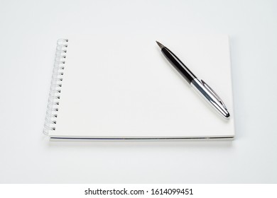 white office Desk top view with Notepad and pen,minimalistic design,top view,copy space,flat lay