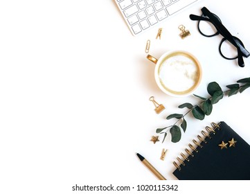 White Office Desk Workspace With Coffee, Paper Blank, Green Leaves And Office Supplies. Flat Lay, Top View, Mockup. 