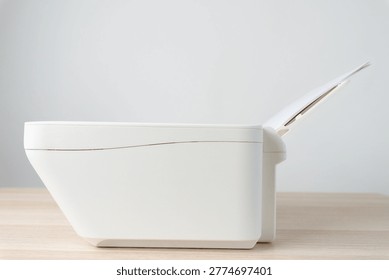White office printer with a stack of blank A4 paper loaded in the feeder tray, shown in a clean minimalist workspace. Conceptual image for printing, office equipment, productivity and documentation.