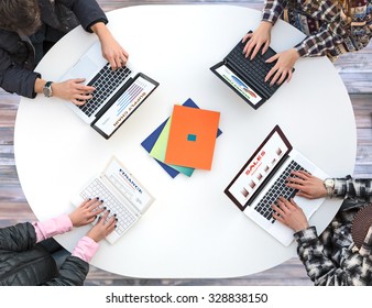 White Office Round Table And Men And Women Working On Computer Top View Casual Clothing Typing On Keyboard Many Laptops Charts Related To Corporate Functions On Every Screen