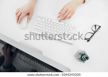 White Office Table and Woman Working on Computer. Top View. Typing on Keyboard