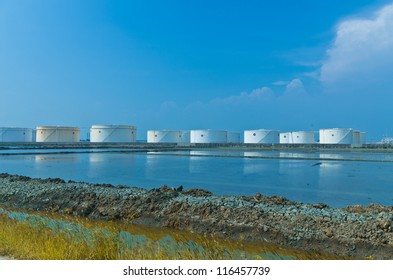 White Oil Tanks In Tank Farm With Blue Sky.